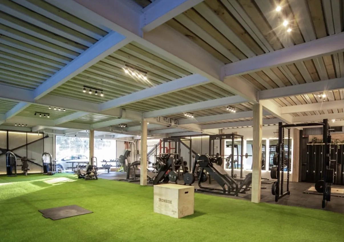 Sala de turf con plyo box, máquinas y techo de madera